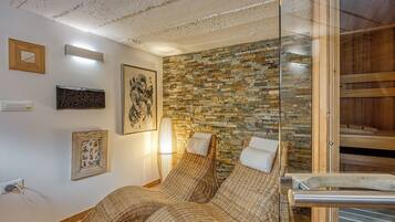 Traditional design with two beds, a large artwork, and a sauna area.
