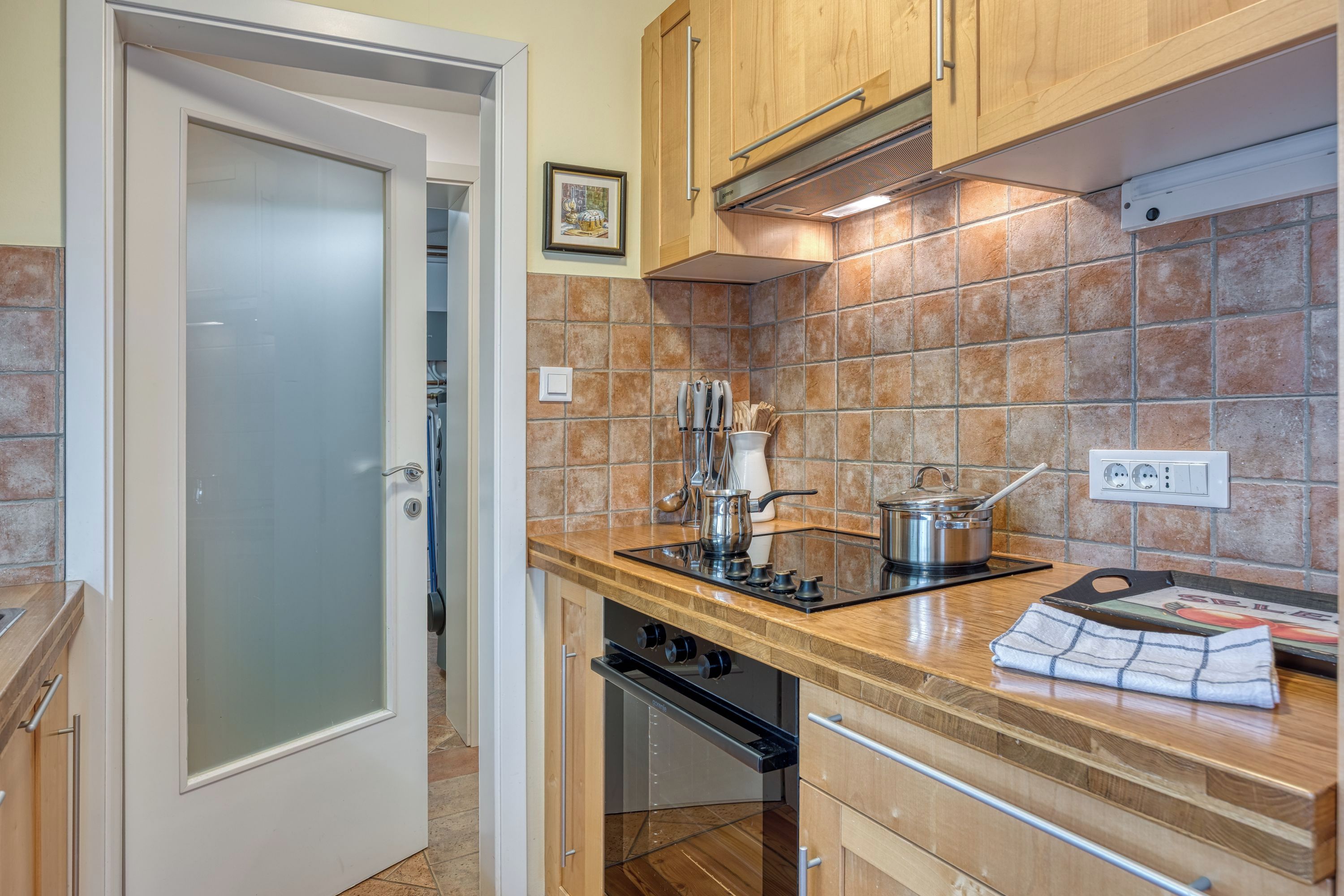 A kitchen with wooden cabinets, a tiled backsplash, a stainless steel stove, and a dishwasher.