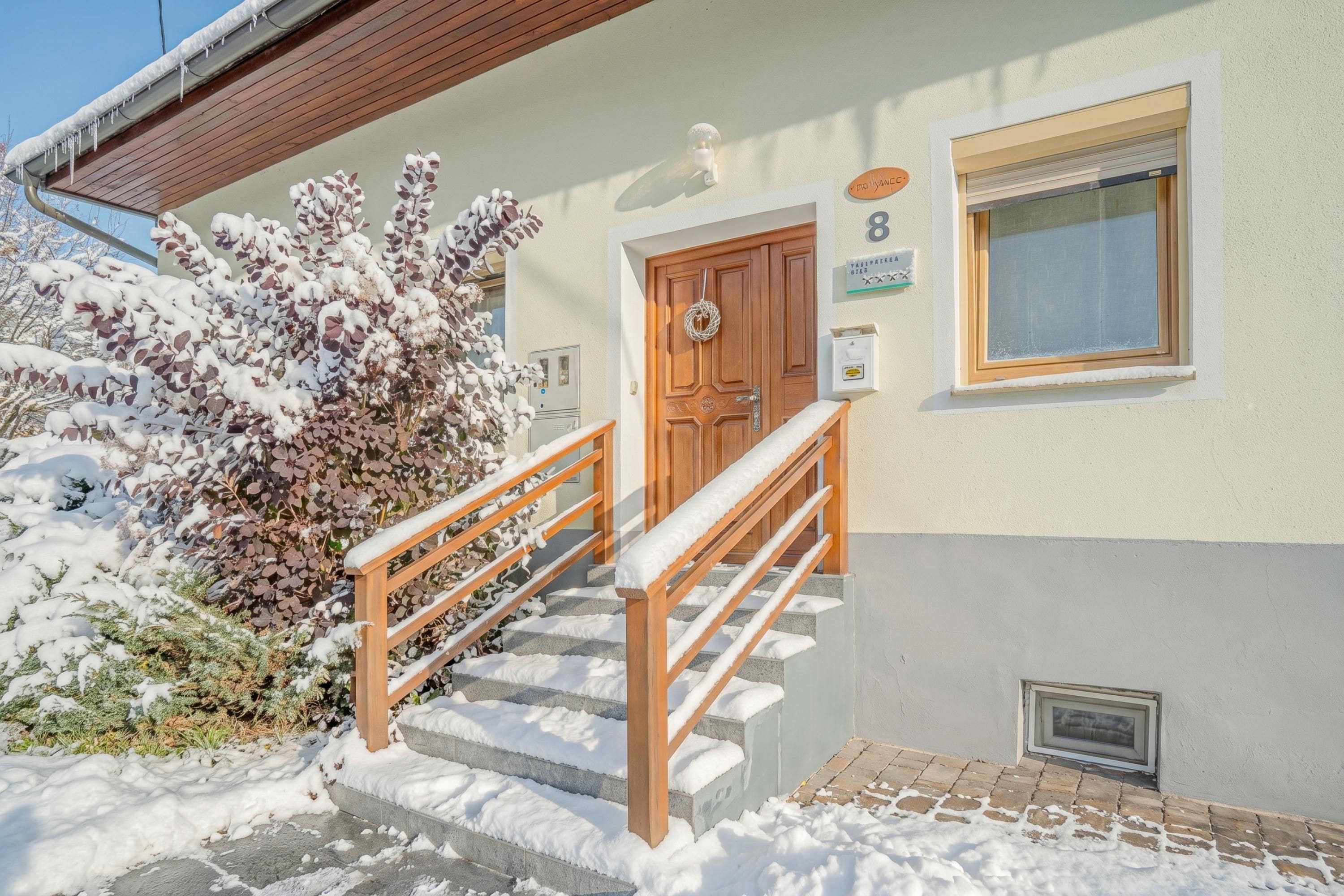 Un bâtiment doté d’un escalier en bois menant à une porte, une fenêtre et une enseigne indiquant le numéro 8.