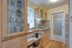 A compact kitchen with wooden cabinets, a built-in sink, and a coffee maker. - Alpine Chalet Planica With Sauna (Kranjska Gora)