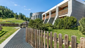 Ein modernes Gebäude mit Flachdach, Holzlattenzaun und gepflastertem Weg.