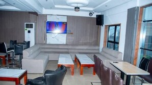 Uma sala de conferências moderna com palco, assentos e uma tela grande.