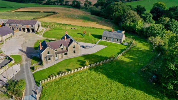 A large stone house with a spacious yard, surrounded by rolling hills and greenery. - Segrwyd Uchaf (Denbigh)