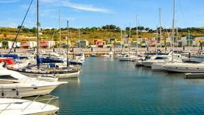 A marina with multiple boats docked, surrounded by colorful buildings and greenery. - Spacious 4 bedroom villa with pool, near beach, ideal for families (Olhos de Água)