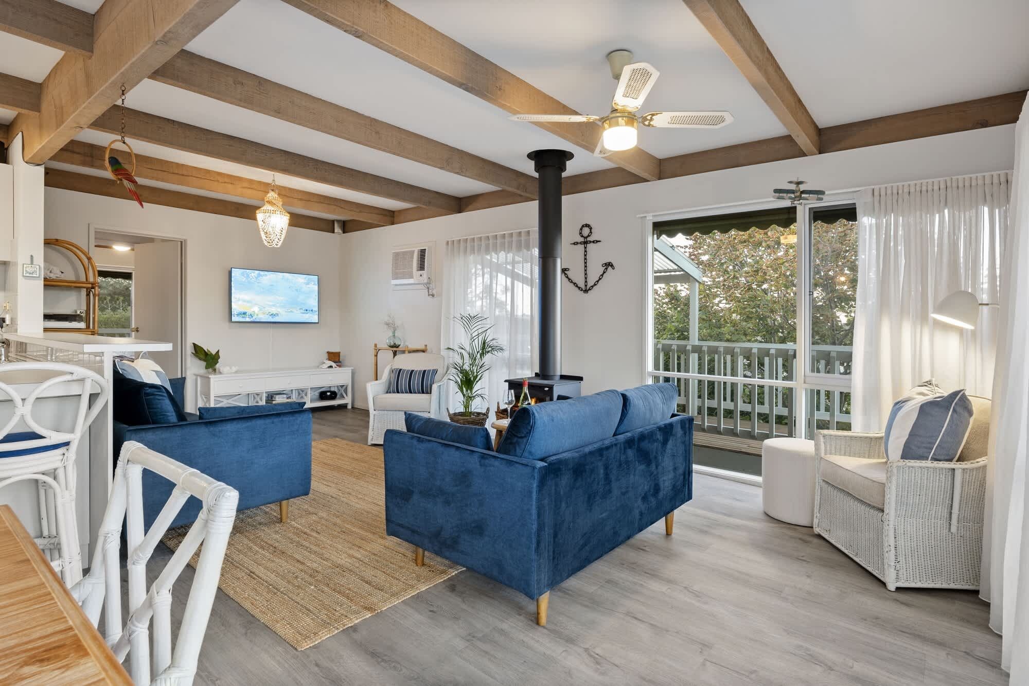 A spacious living room with a large sofa, a TV, and a fireplace.