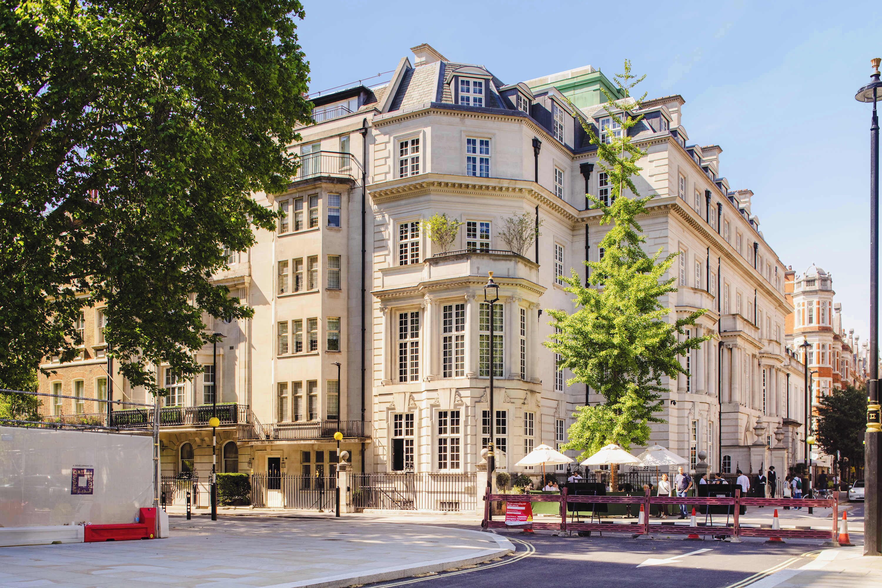 A historic building with classical architecture, a courtyard, and a street view.