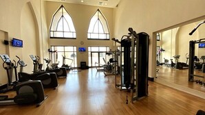 A gym with cardio machines, weight equipment, and large windows. - Durrani Homes - Arabian luxury at Souk Al Bahar besides Burj Khalifa & Dubai Mall (Dubai)