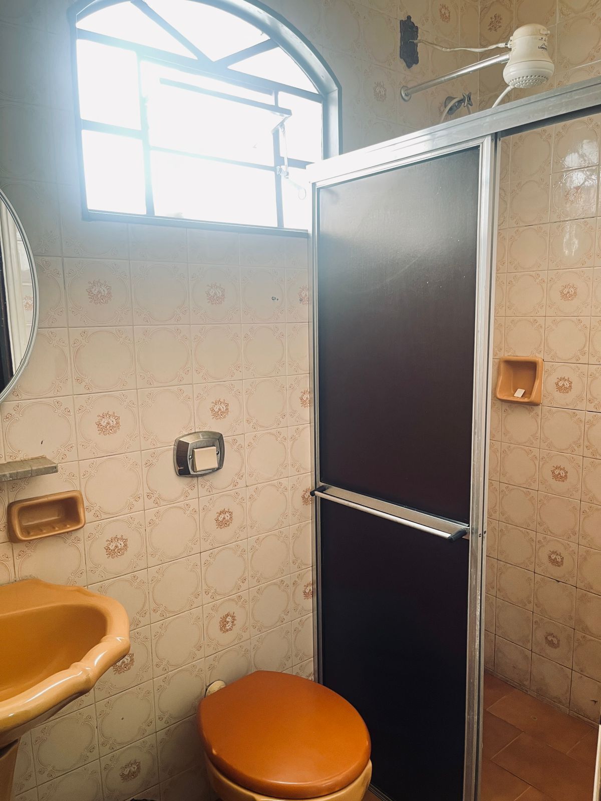 A bathroom with a toilet, sink, and shower.