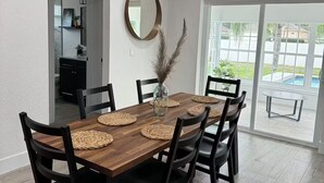 En matplats med ett träbord, svarta stolar och vävda bordstabletter.