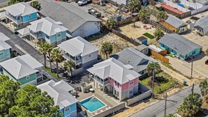 An aerial view of a residential area with multiple houses, a swimming pool, and a street. - Pet-Friendly PCB Vacation Rental | Pool | Walk to Beach (Panama City Beach)