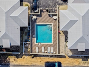 An aerial view of a resort with a central swimming pool, sun loungers, and a covered patio area. - Pet-Friendly PCB Vacation Rental | Pool | Walk to Beach (Panama City Beach)