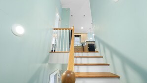 A staircase leading to a kitchen with a view of the upper floor. - Pet-Friendly PCB Vacation Rental | Pool | Walk to Beach (Panama City Beach)