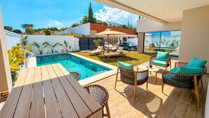 An outdoor patio with a pool, lounge chairs, and a table. - Villa Alba Luxe et Confort a Hammamet (Hammamet)
