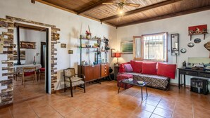 A cozy living room with a fireplace, a sofa, a coffee table, and a dining area with chairs and a table. - Nice home in Ragusa with house a panoramic view (Ragusa)
