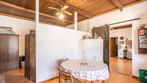 A dining area with a round table, chairs, and a ceiling fan. - Nice home in Ragusa with house a panoramic view (Ragusa)