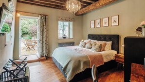 A bedroom with a bed, a dresser, a chair, a window, and a chandelier. - NEW luxury historic apartment, private garden, parking, dog-friendly, in Tetbury (Tetbury)