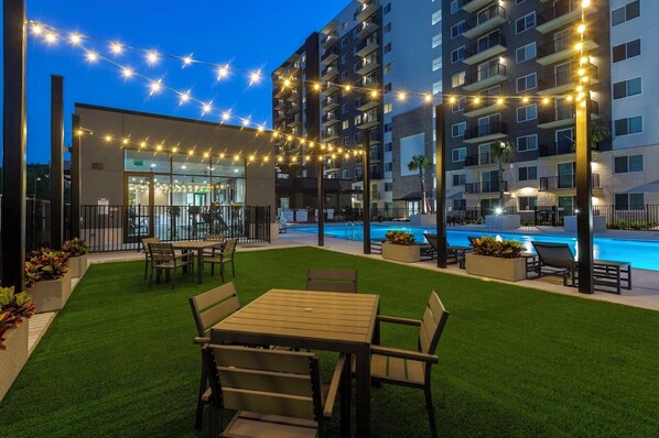 Relax by the pool surrounded by lush greenery and comfortable lounge chairs.