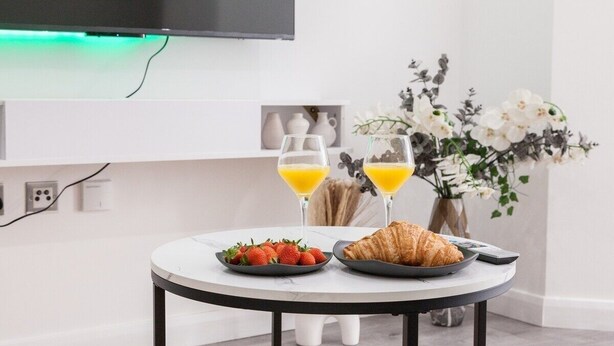 A round table with breakfast items, two glasses of orange juice, and a croissant.