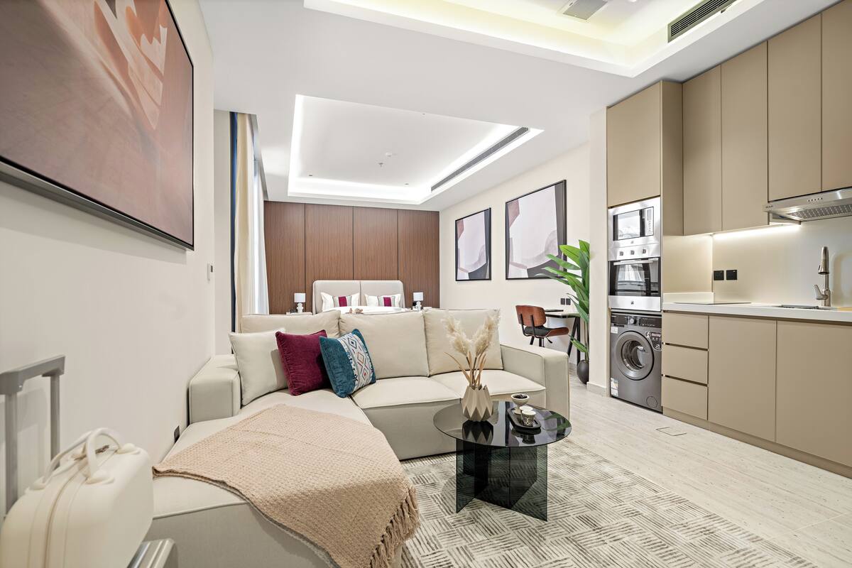 A modern living room with a sofa, coffee table, and a large painting on the wall.