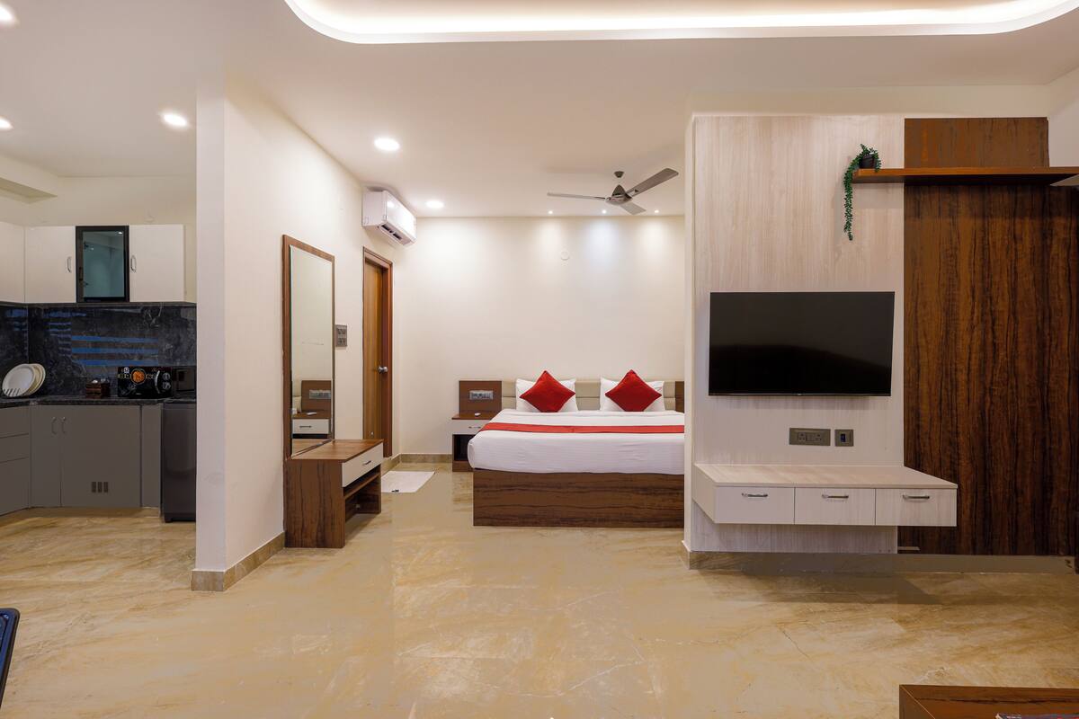 A modern bedroom with a bed, TV, and built-in storage.