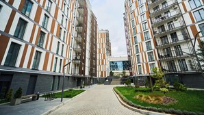 A modern apartment building with a central courtyard, balconies, and a well-maintained garden area. - Modern 1BR - Balcony - in Center by Torro Mall (Chișinău)