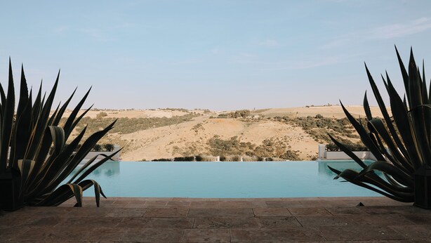 Une piscine avec vue sur un paysage désertique.