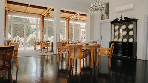 Un espace repas avec des meubles en bois, un lustre et un buffet orné de miroirs ronds.