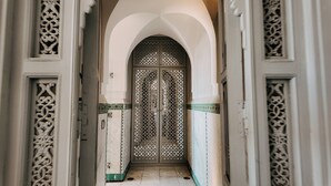 Un couloir orné de portes richement décorées et de motifs complexes sur les murs.