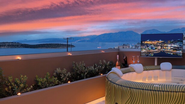 A rooftop terrace with a view of a cityscape at sunset, a pool table, and ambient lighting. - Evilion Home 2 (Agios Nikolaos)