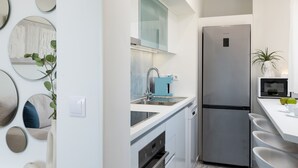 A modern kitchen with a stainless steel refrigerator, a blue coffee machine, and a white countertop. - Evilion Home 2 (Agios Nikolaos)