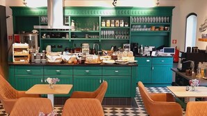 A retro-themed cafe with teal cabinets, checkered flooring, and vintage orange chairs. - Schloss Hohenbocka (Hohenbocka)