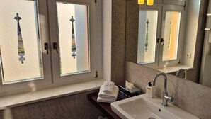 A modern bathroom with a large window, a sink, a mirror, and a towel rack. - Schloss Hohenbocka (Hohenbocka)