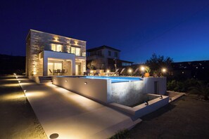 A modern two-story house with a swimming pool, outdoor seating, and well-lit pathways. - Amfitriti Villa  (Kissamos)