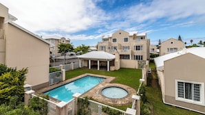 A residential complex with a swimming pool, a hot tub, and a covered patio area. - Modern Executive Unit (East London)
