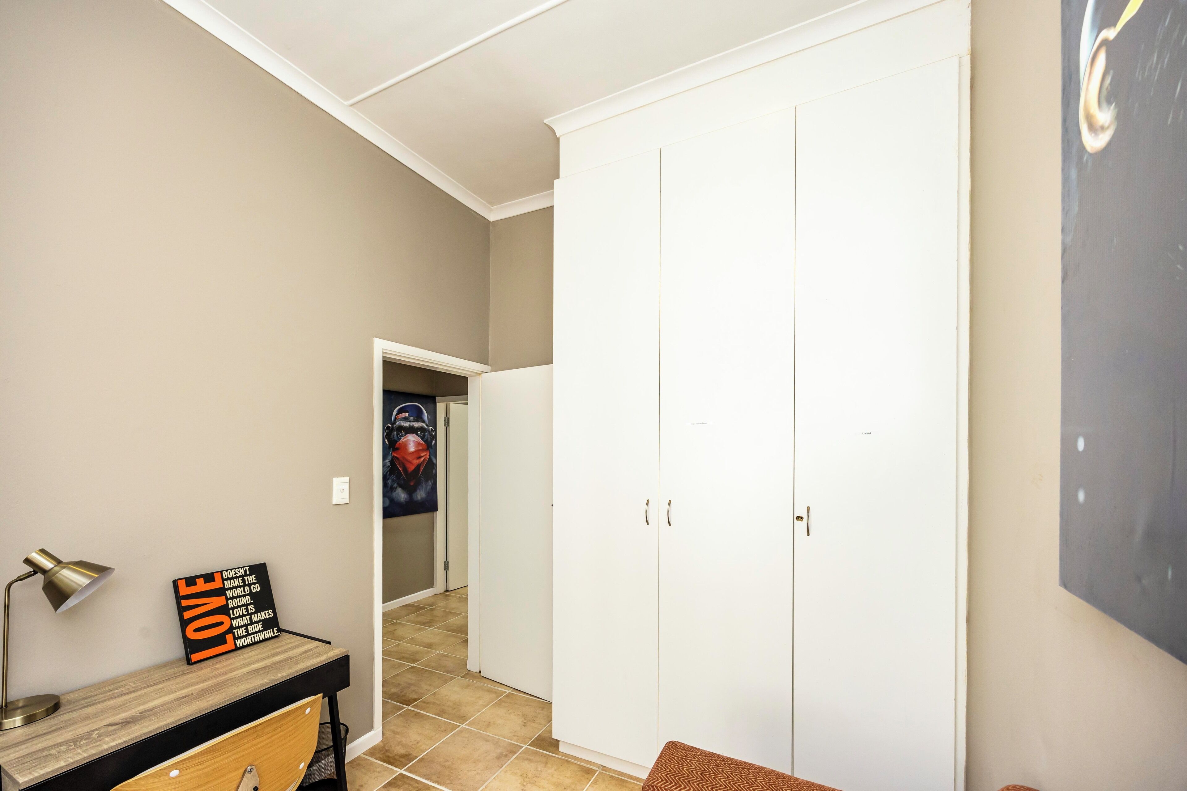 A hallway with a desk, a sign, and a wardrobe.