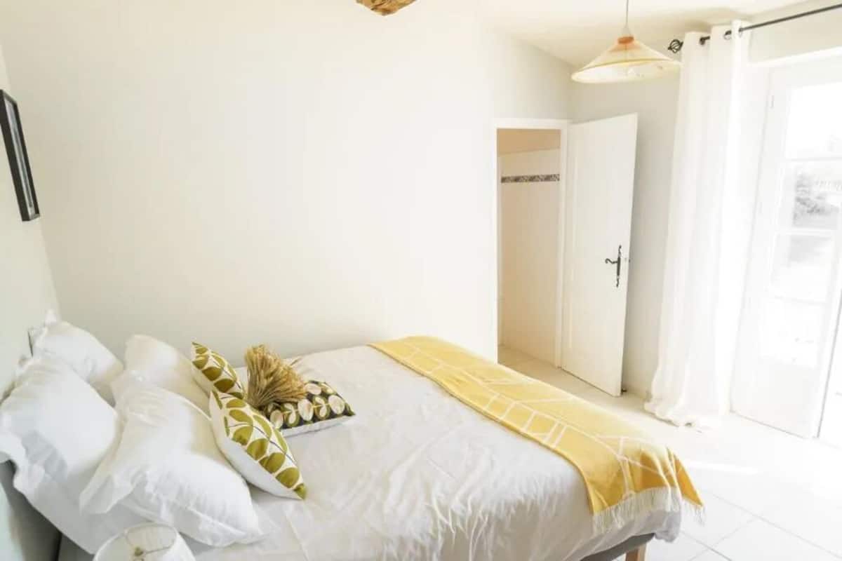 Una camera da letto con un letto, un comodino, una lampada e una trave in legno al soffitto.