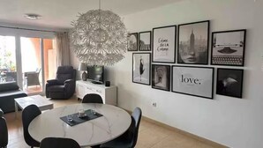 A modern dining area with a round table, black chairs, and a decorative chandelier. - Ground floor South facing apartment (Murcia)