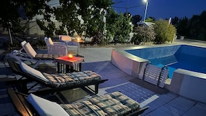 An outdoor pool area with lounge chairs and a table with a candle. - Big and comfortable country house with garden in "Finca La Guindilla" with Pool (El Pico)