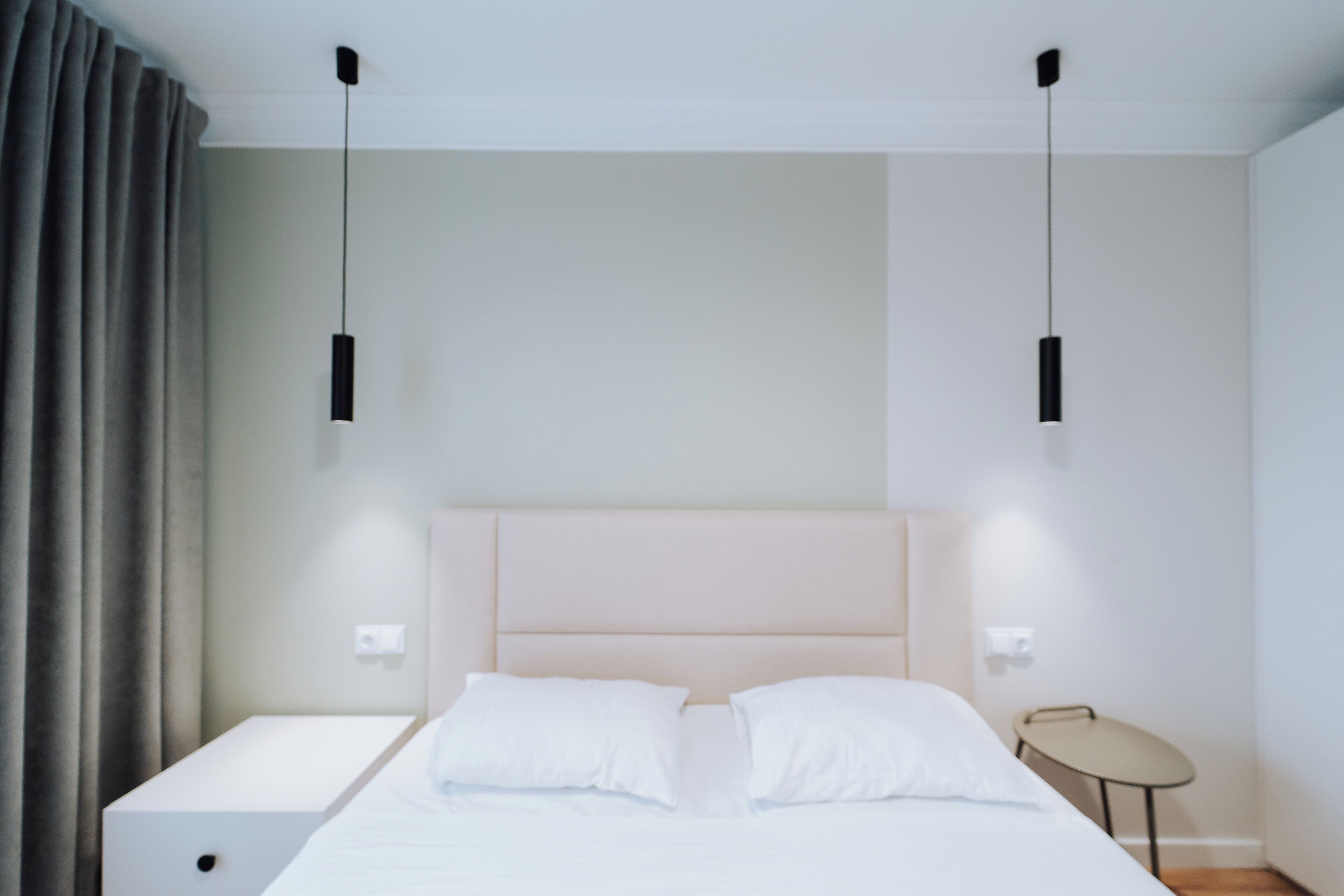 A modern bedroom with a bed, bedside tables, and a small table.
