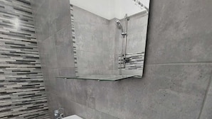 A bathroom with a white sink, a mirror, and a shower. - Tudor Apartment Universitate (Bucharest)