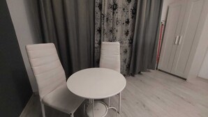 A room with a round table and two white chairs. - Tudor Apartment Universitate (Bucharest)