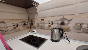 A kitchen with a double electric stove, a kettle, and a sink. - Tudor Apartment Universitate (Bucharest)