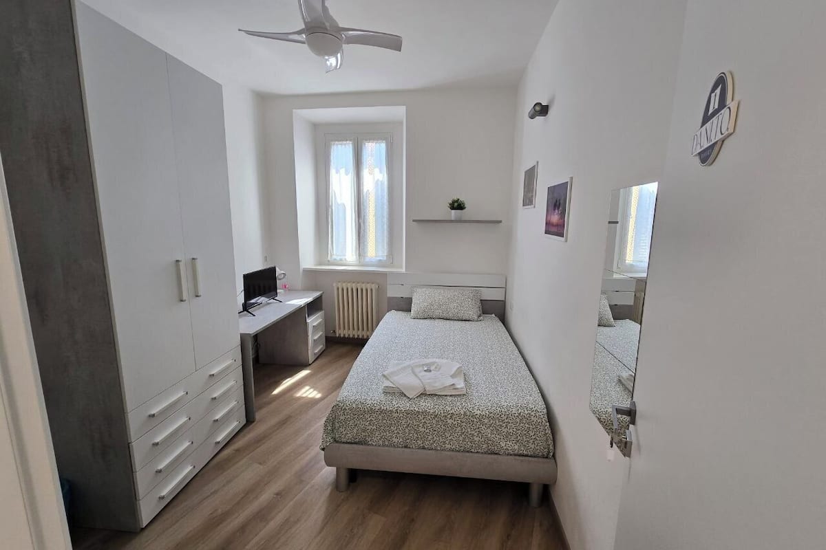 Una camera da letto con un letto, una scrivania, un armadio e una finestra.