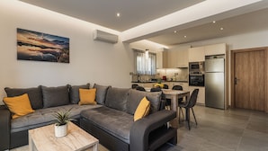 A modern living room with a sectional sofa, a dining table, and a kitchen area with appliances. - Lumior Villas Lux essence by 'elite' (Zakynthos)