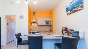 Cocina compacta con isla central, microondas y cafetera.
