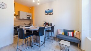 Una cocina compacta con zona de comedor, un sofá y una pequeña mesa.