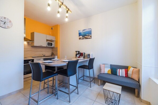 Una cocina compacta con zona de comedor, un sofá y una pequeña mesa.