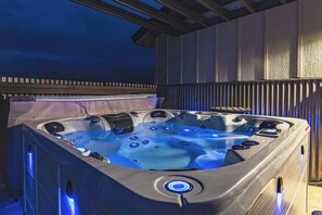 A hot tub with a wooden deck and a covered area.