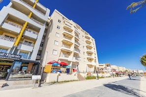 Hotel features modern architecture with balconies on each floor, a ground-level restaurant and pizzeria, and a convenient street location.
