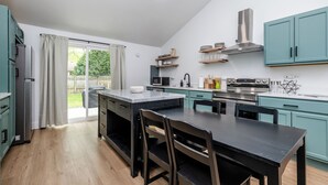 A modern kitchen with a central island, built-in appliances, and teal cabinetry. - 2027 OPEN! (Unit B) Lakeside Home Close To Private Association Beach! (Lakeside)